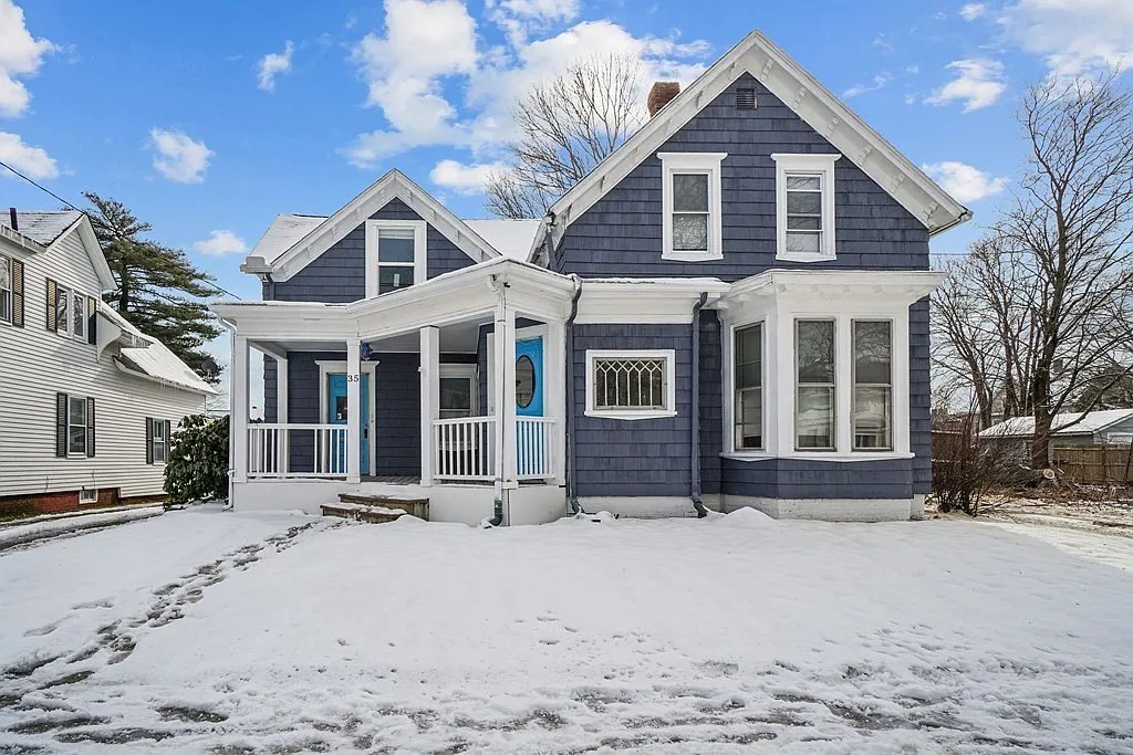 Snow-covered blue house with white trim.