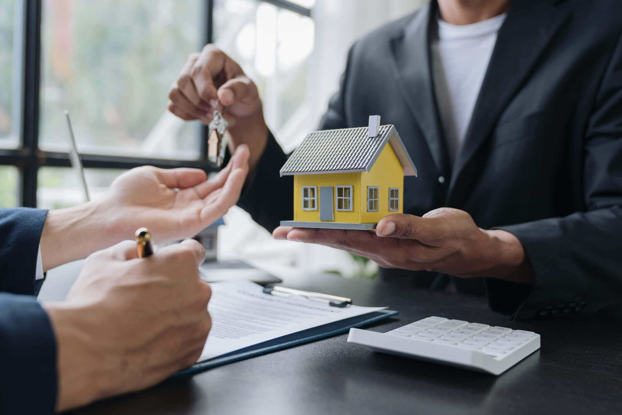 Real estate agent handing over house keys.