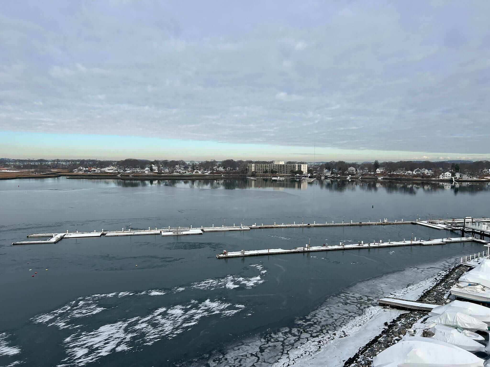 Snowy marina and waterfront houses.