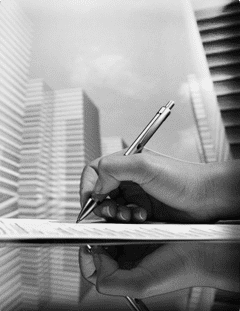 Here's an alt tag for the image: Hand signing document, city backdrop.
